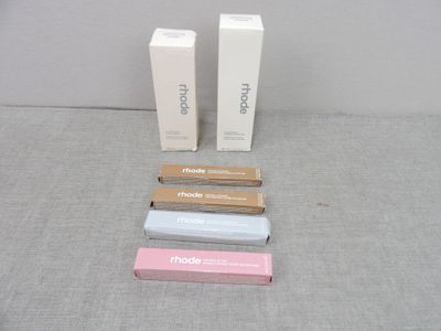 trois tubes de dentifrice posés sur une table, à côté d'un tube de dentifrice