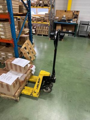 un chariot élévateur chargé de cartons dans un entrepôt