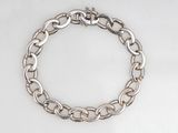 gros plan d'un bracelet en chaîne en argent sur une surface blanche