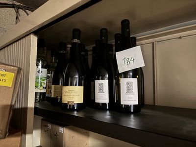 de nombreuses bouteilles de vin sur une étagère dans un magasin