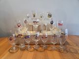 bottles and glasses are lined up on a wooden tray on a table
