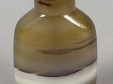 a small glass vase with a green and white stripe around it