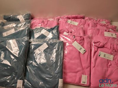 beaucoup de t-shirts roses et bleus sur une étagère