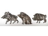 trois figurines en argent représentant des sangliers sur fond blanc