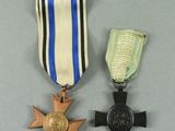 a close up of two medals and a cross on a table