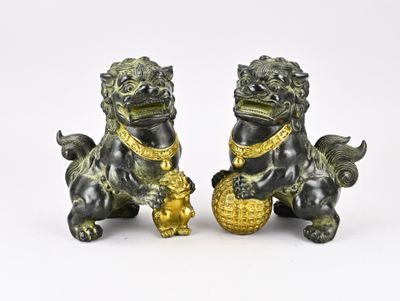 une paire de figurines « foo foo foo » noires et dorées sur fond blanc