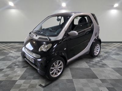 a small black and white smart car on a checkered floor