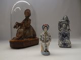 three figurines sitting under a glass dome on a table