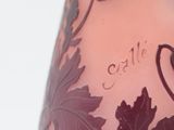 a purple vase with a design of leaves on it