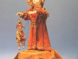 a picture of a doll that is sitting on a pillow