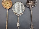 three spoons and a mirror sitting on a table
