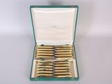 a green case with a set of six knives in it
