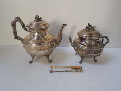 une théière en argent et une théière en argent posées sur une table