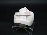 a white marble object with a cross on it on a black surface