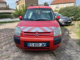 a small red car parked on the side of the road