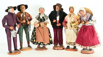 seven figurines of people dressed in traditional clothing