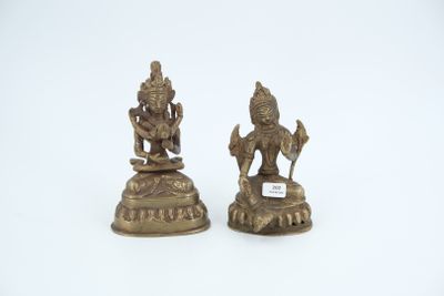 pair of brass figurines of hindu deities on a white background