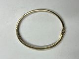 a close up of a gold bracelet on a white surface