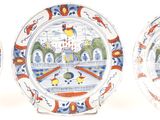 three plates with designs on them are sitting on a stand