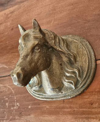 une tête de cheval accrochée au mur au-dessus d'une table en bois