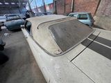 a white car parked in a garage with other cars in the background