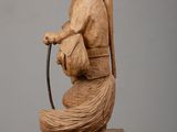wooden sculpture of a monkey holding a baseball bat on a wooden block
