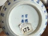 someone is holding a blue and white plate with chinese writing on it