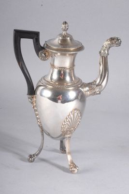 une théière ancienne en argent, dotée d'une anse noire et posée sur un socle