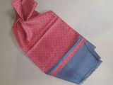 pink and blue scarf with red circles on it laying on a white surface