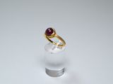 an image of a gold ring with a red stone in it