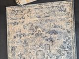 an image of a blue and white area rug with a roll of tape