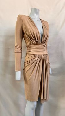 an image of a mannequin wearing a tan dress on a mannequin stand
