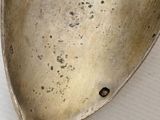 a silver spoon with a handle on a white surface