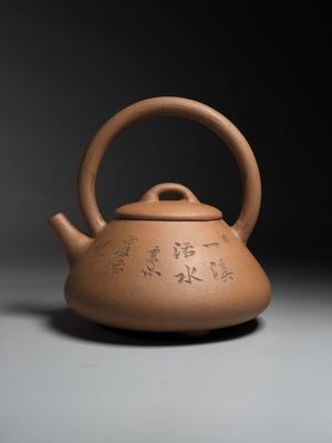 teapot with writing on it on a gray surface