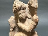 an ancient statue of a woman holding a child