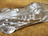 une maquette en verre transparent d'une voiture de course posée sur une table