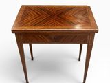 une petite table en bois dont le plateau présente un motif en chevrons