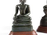 deux statues de bouddhas assis sur un socle en bois