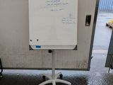 un tableau blanc sur lequel sont écrites des notes, posé sur un support
