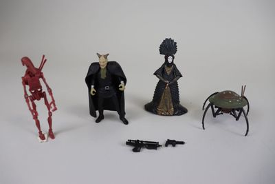 trois figurines représentant différents personnages sur un fond blanc