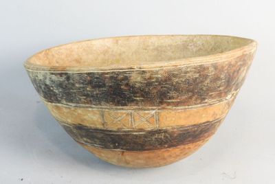 a brown and black bowl sitting on a white surface