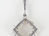 a close up of a pendant on a white surface
