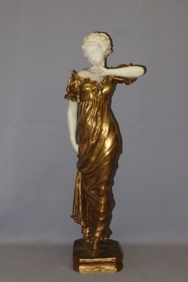 statue of a woman in a gold dress with her hand on her hip
