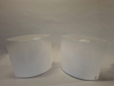 deux vases blancs posés sur une table, sur fond blanc