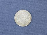 a close up of a silver coin on a blue cloth