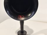 un gramophone noir et rouge posé sur une table blanche