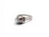 un gros plan d'une bague ornée d'une perle et de diamants