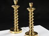 pair of brass candles on a black background