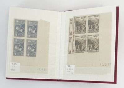 un livre ouvert, orné de timbres, posé sur une surface blanche