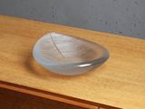 a glass plate with a leaf on top of a wooden dresser
